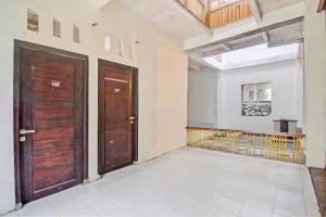 a hallway with two wooden doors and a balcony at Hotel O Kost 99 in Manado