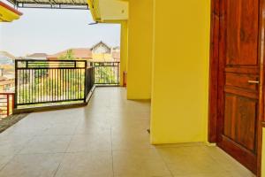 un balcon vide avec un mur jaune et une porte dans l'établissement OYO Life 93036 Eddy Homestay Syariah, à Lamongan