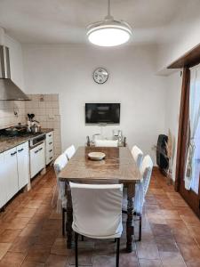 a kitchen with a table with chairs and a clock on the wall at Casa Arenales in Chascomús