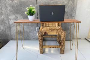 a table with a laptop on a chair with flowers on it at OYO Life Kos Bu Luh Mangku in Tanjung