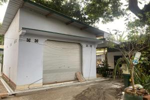 a garage door on a house with writing on it at OYO Life Kos Bu Luh Mangku in Tanjung