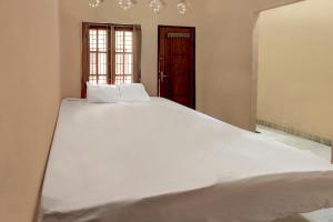 a large white bed in a room with a window at OYO Life 92846 Kost Putra Griya Eka in Tanjungkarang +17 photos