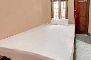 a large white bed in a room with a window at OYO Life 92846 Kost Putra Griya Eka in Tanjungkarang