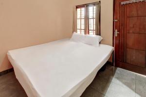 a large white bed in a room with a window at OYO Life 92846 Kost Putra Griya Eka in Tanjungkarang