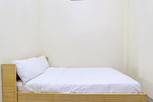 a bed with a wooden frame in a room at OYO Life 92663 Karmel 6 in Purwokerto