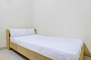 a bed with white sheets on it in a room at OYO Life 92663 Karmel 6 in Purwokerto