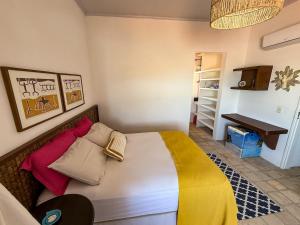 a bedroom with a bed with colorful pillows on it at Varanda do Oceano Maracajaú in Maxaranguape +10 photos