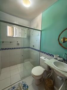 a bathroom with a shower and a toilet and a sink at Varanda do Oceano Maracajaú in Maxaranguape