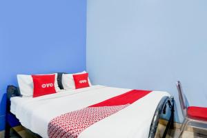 a bed with red and white pillows on it at OYO Life 93083 Nova Jaya 3 Homestay Syariah in Lamongan