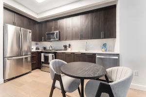 a kitchen with a table and two chairs and a refrigerator at Queens Studio Jewel Luxury and Comfort Combined in Mary Immaculate Hospital Heliport +13 photos