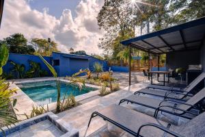 a patio with a pool and a table and chairs at Villas y Casa Dìwö - Puerto Viejo in Hone Creek