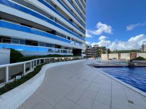 a large building with a walkway next to a pool at Lindo apartamento 1 4 frente mar in Salvador