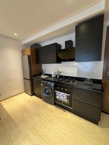 a kitchen with a stove and a washing machine at Beau studio au cœur du parc in Mohammedia