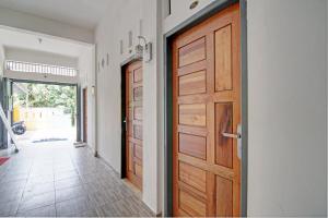 a hallway with two wooden doors and a hallway with a floor at Hotel O Celine Home Syariah in Parit