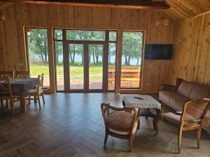 un soggiorno con un divano, un tavolo e delle sedie di Holiday Home by Lake Wierzchowo with Private Beach a Grąbczyn