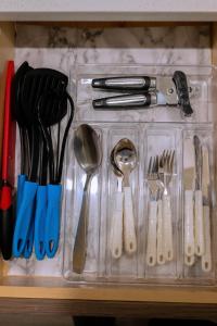 a plastic container with utensils in a drawer at Modern and Private Guest Suite in Regina, SK in Regina +8 photos