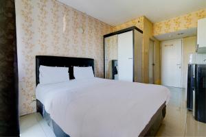 カラワンにあるOYO Life 92874 Apartement Grand Sentraland Karawang By Red Dragonの大きな白いベッドとキッチンのある寝室 +17枚の写真