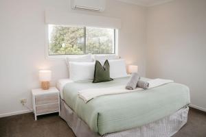 ein Schlafzimmer mit einem großen Bett mit Fenster in der Unterkunft Port Campbell Coastal Unit 2 in Port Campbell