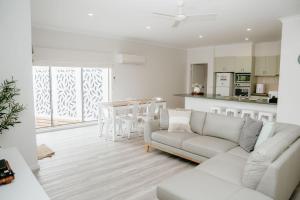 ein weißes Wohnzimmer mit einer Couch und einem Tisch in der Unterkunft Port Campbell Coastal Unit 2 in Port Campbell