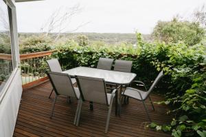 einen Tisch und vier Stühle auf einer Holzterrasse in der Unterkunft Port Campbell Coastal Unit 2 in Port Campbell