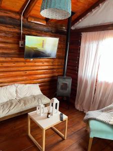 a living room with a couch and a stove at Cabaña Puesta del sol in Chascomús +44 photos