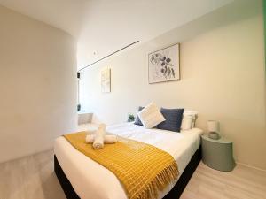 ein Schlafzimmer mit einem Bett mit einer gelben Decke in der Unterkunft QV Spacious 2BR APT CityCentre State Library in Melbourne + 25 Fotos