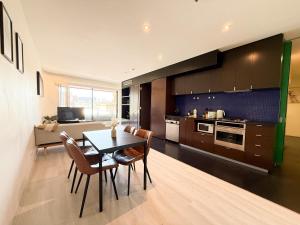 eine Küche und ein Esszimmer mit Tisch und Stühlen in der Unterkunft QV Spacious 2BR APT CityCentre State Library in Melbourne