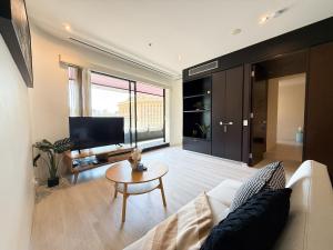 ein Wohnzimmer mit Sofa und Fernseher in der Unterkunft QV Spacious 2BR APT CityCentre State Library in Melbourne