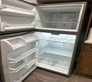 エドモントンにあるModern Basement Suite - Close Edmonton International Airportのキッチンにあるドアが開いたままの空の冷蔵庫