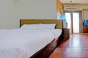 een slaapkamer met een groot bed met witte lakens bij OYO Life 92949 Apartemen Gateway Cicadas By Qq Rent in Bandung