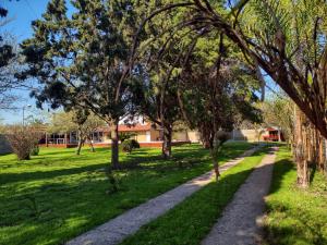 Un camino a través de un parque con árboles y césped. en Casa Quinta La Aves, en Estación La Plata