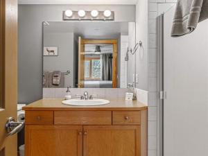 un baño con lavabo y espejo en Creekside Downtown 2 Bedroom Condo managed by Little Sister Getaways, en Canmore 28 fotos más