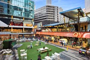 eine Gruppe von Menschen, die in einer Stadt mit Gebäuden spazieren in der Unterkunft QV Spacious 2BR APT CityCentre State Library in Melbourne