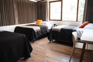 a room with two beds and a window at Central Hostel Dolce Vita in Guatemala