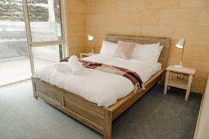 un grand lit dans une chambre avec une fenêtre dans l'établissement Bayview no 1, à Port Campbell