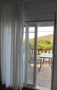 a sliding glass door to a patio with a table at Ena-Lia Studios in Skala Marion