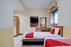 ParitにあるHotel O Harapan Homestay SyariahNearDamai Langgeng Parkのベッドが2つと窓があるホテルの部屋 +18枚の写真