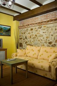 sala de estar con sofá y pared de ladrillo en Apartamentos Rurales Cumbres de Gredos, en Jaraíz de la Vera