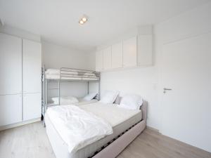 a white bedroom with a bunk bed and white cabinets at Stylish City-View Retreat in Knokke-Heist