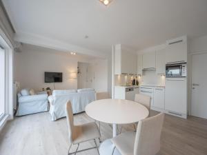 a kitchen and living room with a white table and chairs at Stylish City-View Retreat in Knokke-Heist