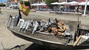 a grill with chickens and other food on it at Apartamento Marion in Cala del Moral