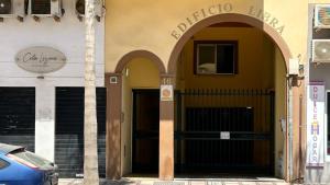 a building with two arched doors and a car parked outside at Apartamento Marion in Cala del Moral