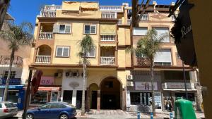 a building with palm trees in front of a street at Apartamento Marion in Cala del Moral