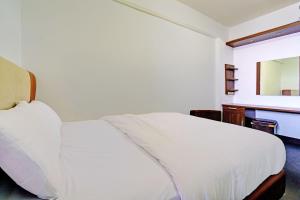 een slaapkamer met een wit bed en een bureau bij OYO Life 92949 Apartemen Gateway Cicadas By Qq Rent in Bandung +22 foto's