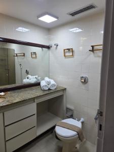 a bathroom with a toilet and a sink and a mirror at Ondina Apart Hotel AP in Salvador