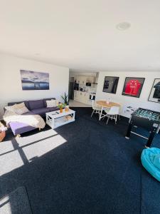ein Wohnzimmer mit Sofa und Tisch in der Unterkunft Papamoa Family Beach House in Tauranga