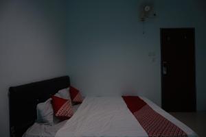 une chambre avec un lit avec des oreillers rouges et blancs dans l'établissement Hotel O Mamapapahouse, à Batam Center