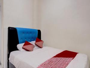 un lit avec des oreillers rouges et blancs dessus dans l'établissement Hotel O Baloi Homestay, à Nagoya 18 autres photos