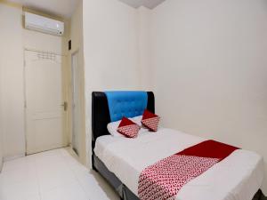 - une chambre avec un lit doté d'une tête de lit bleue et d'oreillers rouges dans l'établissement Hotel O Baloi Homestay, à Nagoya