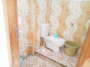 a small bathroom with a toilet and a bucket at Kos Mama Ros in Labuan Bajo +29 photos